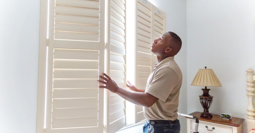 Image of a man opening shutters.